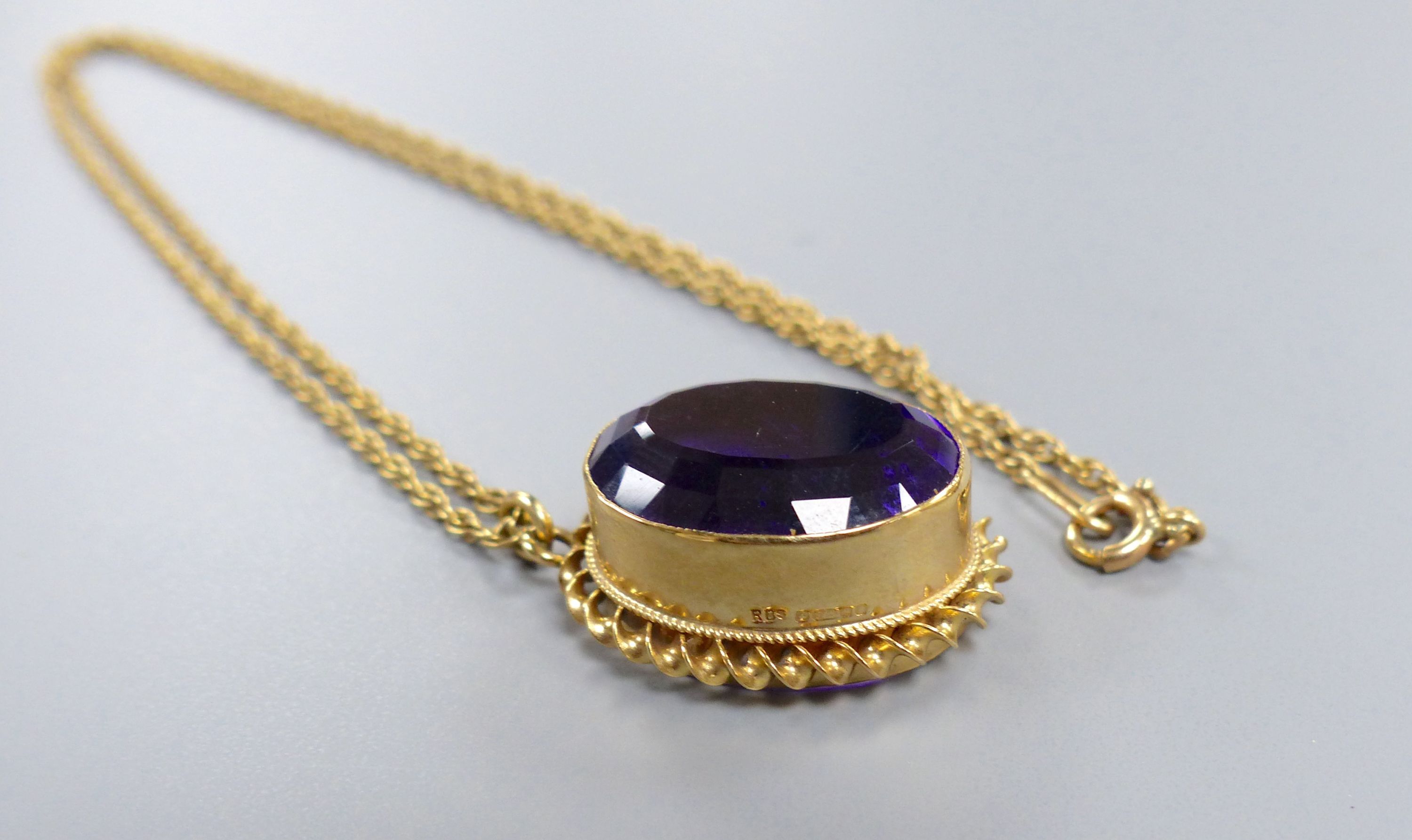 A modern 9ct gold and oval cut amethyst set pendant, 24mm, on a 9ct chain, 46cm,